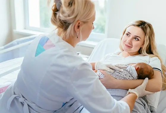 dziecko na rękach mamy oraz lekarz badający dziecko