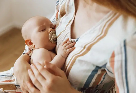 Małe dziecko u mamy na rękach