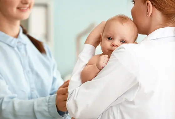 dziecko u pediatry na rękach w trakcie rozmowy z opiekunką